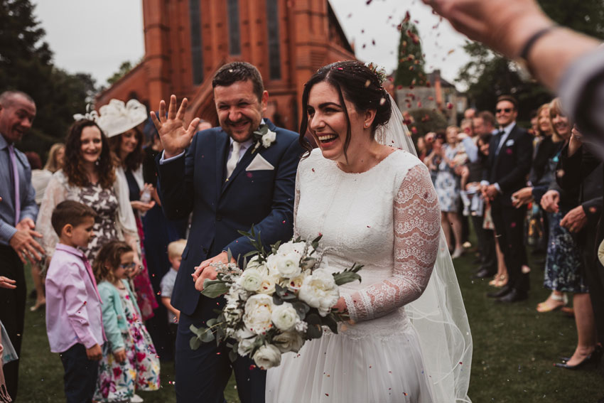 wedding guests throwing confetti on married couple