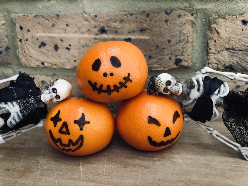 Halloween clementines decorated to look like mini pumpkins