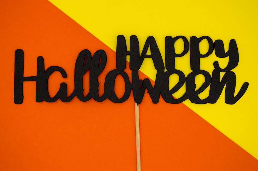 Black Happy Halloween sign on an orange and yellow background - plastic free Halloween decorations