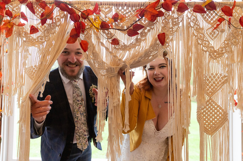 Bride and Groom peeping through crochet decorative curtain