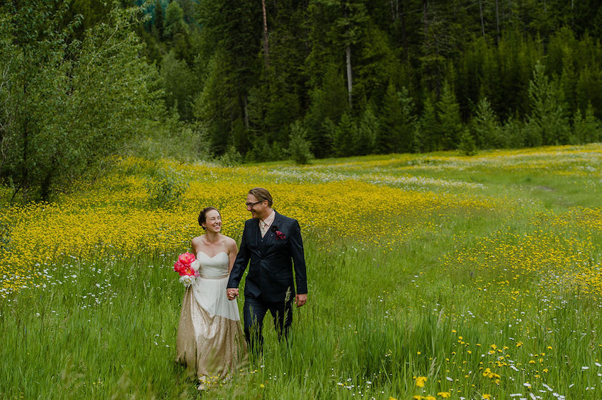 Bride and Groom walking through field of long grass