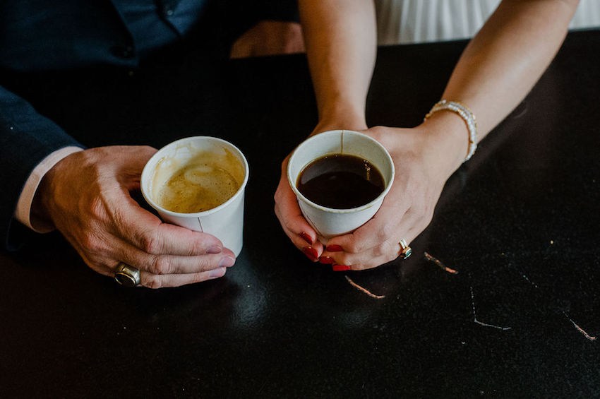 Close up of Bride and Groom's hands holding cups of coffee