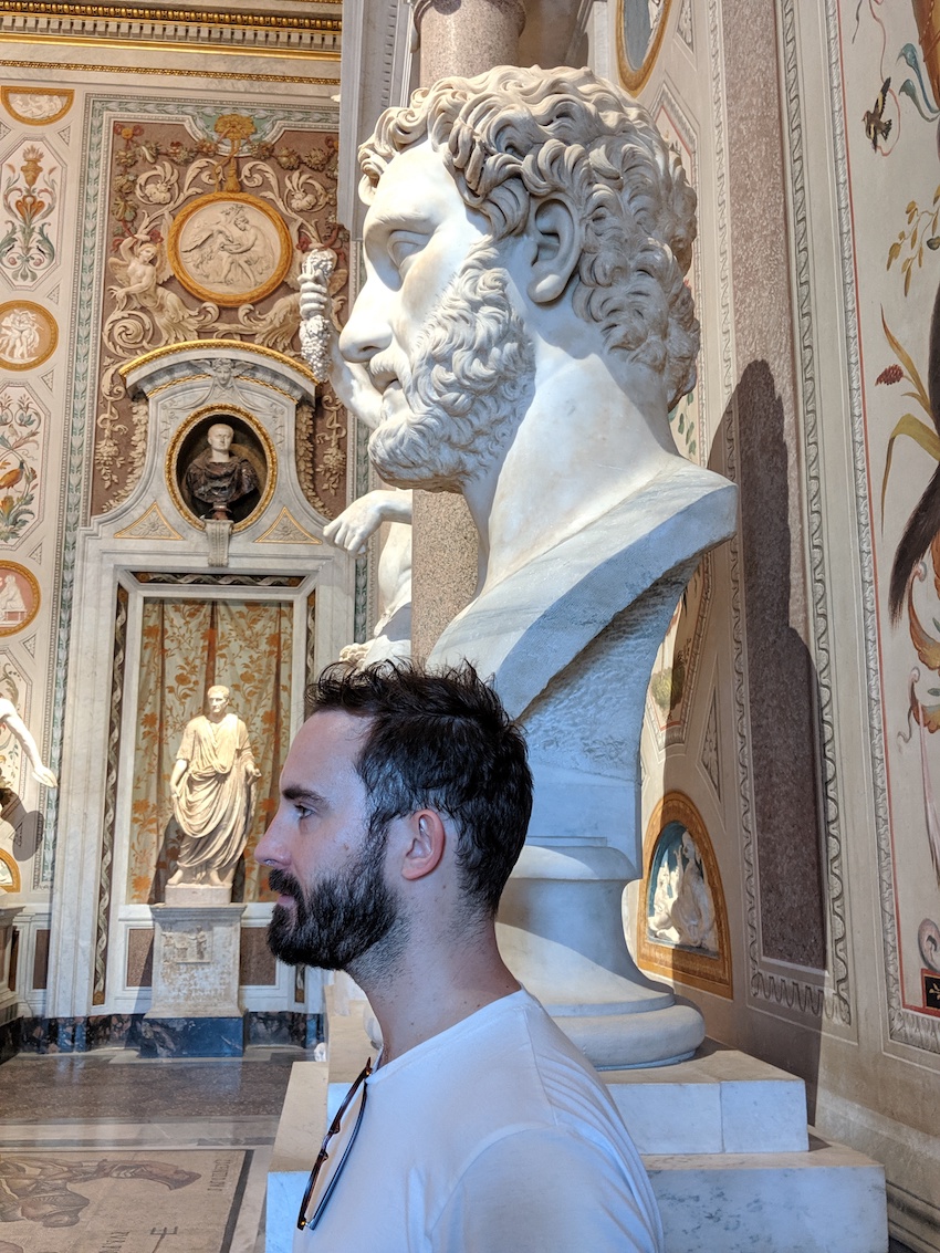 Man standing next to statue in Italy