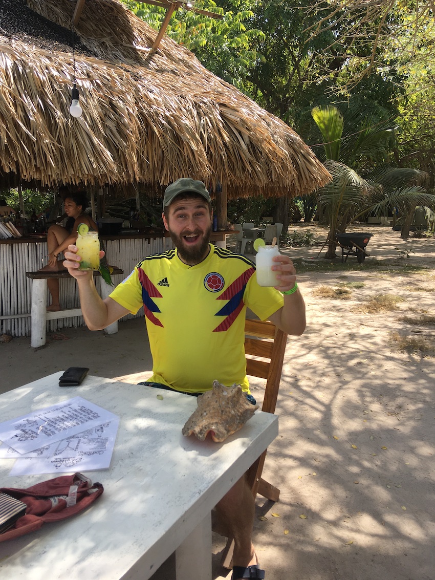 Man on honeymoon in Colombia having cocktails on beach