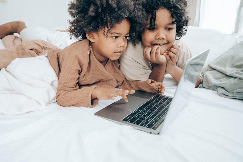 Children playing on laptop on virtual Christmas fair page